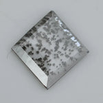 Square step-cut lab grown diamond with dramatic black salt and pepper inclusions, showcasing a unique geometric faceted structure and modern ethical gemstone design