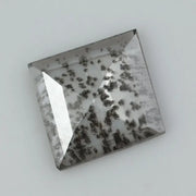 Square step-cut lab grown diamond with dramatic black salt and pepper inclusions, showcasing a unique geometric faceted structure and modern ethical gemstone design