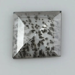 Square step-cut lab grown diamond with dramatic black salt and pepper inclusions, showcasing a unique geometric faceted structure and modern ethical gemstone design