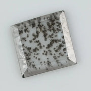 Square step-cut lab grown diamond with dramatic black salt and pepper inclusions, showcasing a unique geometric faceted structure and modern ethical gemstone design