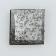 Square step-cut lab grown diamond with dramatic black salt and pepper inclusions, showcasing a unique geometric faceted structure and modern ethical gemstone design