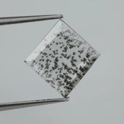 Square step-cut lab grown diamond with dramatic black salt and pepper inclusions, showcasing a unique geometric faceted structure and modern ethical gemstone design