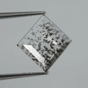 Square step-cut lab grown diamond with dramatic black salt and pepper inclusions, showcasing a unique geometric faceted structure and modern ethical gemstone design