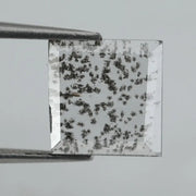 Square step-cut lab grown diamond with dramatic black salt and pepper inclusions, showcasing a unique geometric faceted structure and modern ethical gemstone design