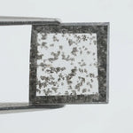 Square step-cut lab grown diamond with dramatic black salt and pepper inclusions, showcasing a unique geometric faceted structure and modern ethical gemstone design