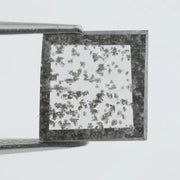 Square step-cut lab grown diamond with dramatic black salt and pepper inclusions, showcasing a unique geometric faceted structure and modern ethical gemstone design