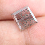 Square step-cut lab grown diamond with dramatic black salt and pepper inclusions, showcasing a unique geometric faceted structure and modern ethical gemstone design