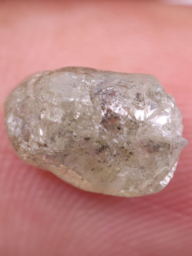 Raw diamond held between fingers