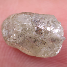 Raw diamond held between fingers