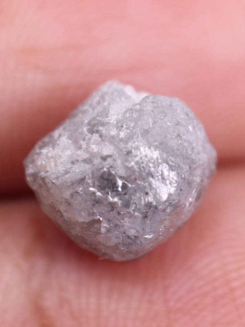 Raw diamond held between fingers