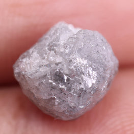 Raw diamond held between fingers