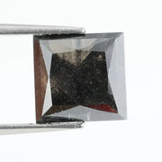 Close-up of a square princess cut black lab-grown diamond with precise facets, reflecting light, showcasing ethical and sustainable luxury gemstone quality.