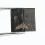 Close-up of a square princess cut black lab-grown diamond with precise facets, reflecting light, showcasing ethical and sustainable luxury gemstone quality.