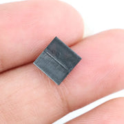 Close-up of a square princess cut black lab-grown diamond with precise facets, reflecting light, showcasing ethical and sustainable luxury gemstone quality.