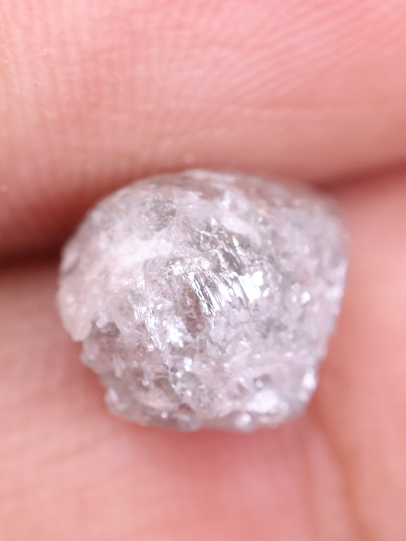 Raw diamond held between fingers