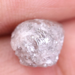 Raw diamond held between fingers