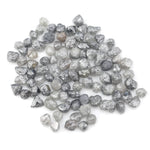 grey black natural diamond with a rugged raw surface and uncut profile