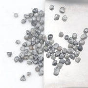 grey black natural diamond with a rugged raw surface and uncut profile
