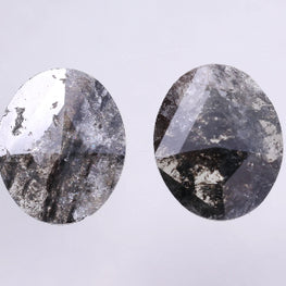 Pair of oval-shaped salt and pepper diamond on a light gray background