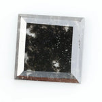 Sqaure step cut salt and pepper lab grown diamond with galaxy-like black and white inclusions, featuring a geometric faceted shape and transparent edges, ideal for unique engagement rings or custom jewelry designs