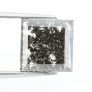 Sqaure step cut salt and pepper lab grown diamond with galaxy-like black and white inclusions, featuring a geometric faceted shape and transparent edges, ideal for unique engagement rings or custom jewelry designs