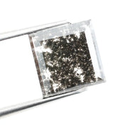 Sqaure step cut salt and pepper lab grown diamond with galaxy-like black and white inclusions, featuring a geometric faceted shape and transparent edges, ideal for unique engagement rings or custom jewelry designs