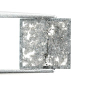 Sqaure step cut salt and pepper lab grown diamond with galaxy-like black and white inclusions, featuring a geometric faceted shape and transparent edges, ideal for unique engagement rings or custom jewelry designs