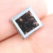 Sqaure step cut salt and pepper lab grown diamond with galaxy-like black and white inclusions, featuring a geometric faceted shape and transparent edges, ideal for unique engagement rings or custom jewelry designs