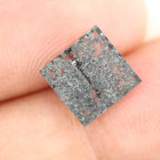 Sqaure step cut salt and pepper lab grown diamond with galaxy-like black and white inclusions, featuring a geometric faceted shape and transparent edges, ideal for unique engagement rings or custom jewelry designs