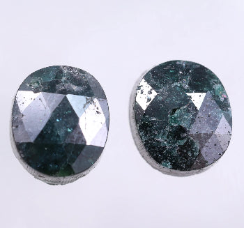 Two oval-shaped green diamond on a light gray background