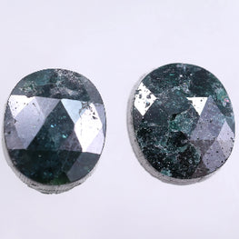 Two oval-shaped green diamond on a light gray background