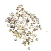 Natural multi colour rough diamonds with yellow, grey, champagne and white tones displayed on white background.