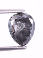 pear - shaped diamond held between tweezers on a white background