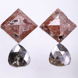 Pair of earrings with square and teardrop-shaped diamond on a light gray background