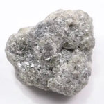 A close-up view of a grey diamond showcasing its unique salt-and-pepper appearance with visible mineral inclusions.
