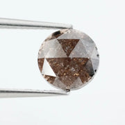 Close-up of a premium round cut brown lab-grown diamond with sparkling facets, showcasing eco-friendly, conflict-free quality and unique natural-like inclusions.