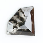 Geometric cut salt and pepper lab grown diamond with smoky black and white inclusions, showcasing a unique faceted shape and modern ethical gemstone design on a clean white background