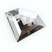Geometric cut salt and pepper lab grown diamond with smoky black and white inclusions, showcasing a unique faceted shape and modern ethical gemstone design on a clean white background