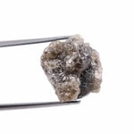A side view of a grey diamond engagement ring, featuring the gem's distinctive speckles and smoky hues, set in platinum.