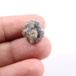 A side view of a grey diamond engagement ring, featuring the gem's distinctive speckles and smoky hues, set in platinum.