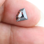 Geometric cut salt and pepper lab grown diamond with smoky black and white inclusions, showcasing a unique faceted shape and modern ethical gemstone design on a clean white background
