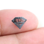 Geometric cut salt and pepper lab grown diamond with smoky black and white inclusions, showcasing a unique faceted shape and modern ethical gemstone design on a clean white background