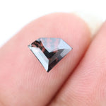 Geometric cut salt and pepper lab grown diamond with smoky black and white inclusions, showcasing a unique faceted shape and modern ethical gemstone design on a clean white background