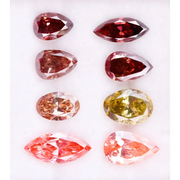 Eight faceted lab grown colored diamonds in pear, oval, and marquise cuts featuring fancy pink, yellow, and deep red tones arranged on a white background.