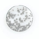 Close-up of a round, lab-grown diamond with black and white speckled inclusions, sparkling facets, and jewelry-grade clarity, ethically sourced and crafted for fine jewelry