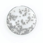 Close-up of a round, lab-grown diamond with black and white speckled inclusions, sparkling facets, and jewelry-grade clarity, ethically sourced and crafted for fine jewelry