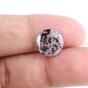 Close-up of a round, lab-grown diamond with black and white speckled inclusions, sparkling facets, and jewelry-grade clarity, ethically sourced and crafted for fine jewelry