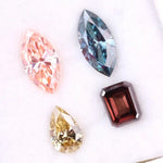 Set of four fancy color lab grown diamonds including emerald cut brown, pear shape yellow, marquise blue and pink loose diamonds for custom fine jewelry