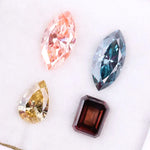 Set of four fancy color lab grown diamonds including emerald cut brown, pear shape yellow, marquise blue and pink loose diamonds for custom fine jewelry