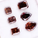 Set of premium brown lab-grown diamonds in emerald, pear, and octagon cuts displaying rich fancy color and brilliant faceting for custom fine jewelry designs.